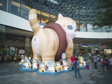 Singapur - 30 Ekim 2025: Yaşamın ötesinde etkileyici, 8 metre boyunda, şişme donut Mofusand karakteri, büyük gözlü, tüylü kızıl kedi, Plaza Singapura 'da, insanlar kalabalıklaşıyor.