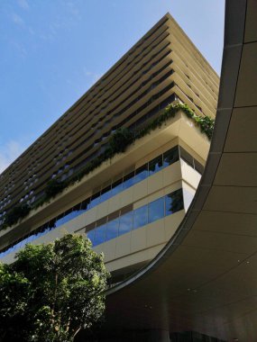 Singapur 'da parlak güneş ışığı altında yansıtıcı cam cepheli modern yüksek ofis binası