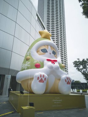 Singapur - 5 Kasım 2025: Raffles City Alışveriş Merkezi 'nde, büyük gözlü, tüylü kızıl kedili, Noel Ağacı Mofusand isimli etkileyici, 8 metre uzunluğunda, şişirilebilir bir karakter.