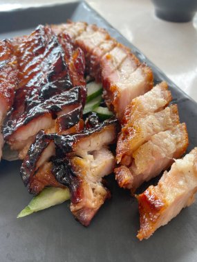 Yakın plan közlenmiş kızarmış domuz göbeği ve ızgara domuz eti. Popüler Asyalı işportacı yemekleri ve restoran yemekleri, zengin, lezzetli ve iştah açıcı yemekler.