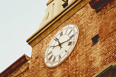 Pisa yakınlarındaki tarihi saate yakın çekim, Roma rakamları, sıcak altın tonlar, eski taş dokusu, İtalyan mimarisi, miras ayrıntıları, Toskana seyahat ilhamı.