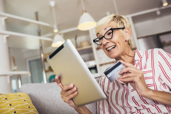Sonriente Mujer Madura Compras Línea Con Tarjeta Crédito Utilizando Tableta —  Fotos de Stock