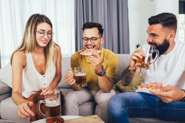 Bir grup genç birlikte eğleniyor. Bira ve pizzayla aydınlık bir odada oturmak..
