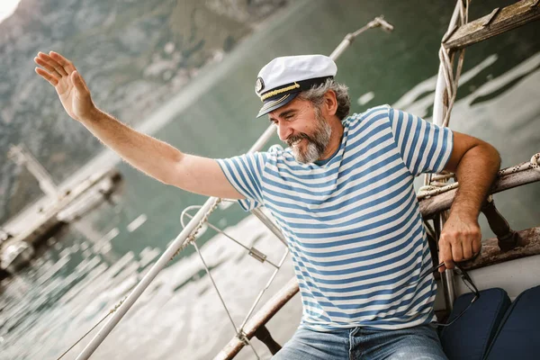 大人の男は 晴れた日の午後に船の舵で海に立っている — ストック写真