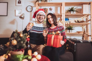 Neşeli adam ve kadın Noel hediyesini evde açarlar..