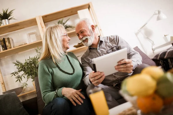 Senior couple using digital tablet at home