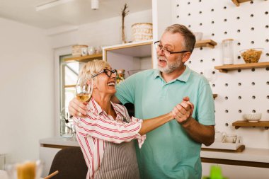 Yaşlı çift mutfakta yemek hazırlıyor, eğleniyorlar..
