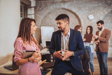 Modern ofiste yeni bir proje üzerinde çalışan iki tasarımcı.