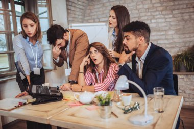 Ofiste takım olarak çalışan iş adamları.