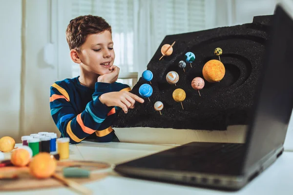 Kid presenting his science home project - the planets of our solar system. Distance learning online education.