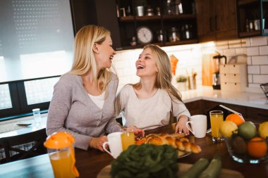 Mutlu anne ve kız kahvaltı hazırlıyor ve birlikte vakit geçiriyorlar.