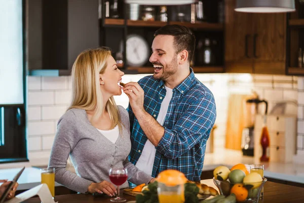 美しい若いカップルは 自宅でキッチンで健康的な食べ物を調理しながら話して笑顔です — ストック写真