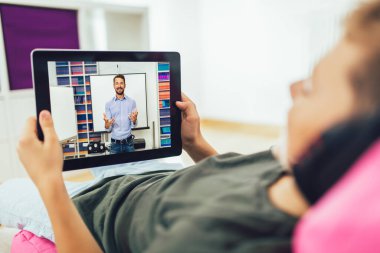 Ödevi için tablet kullanan çocuk portresi. Ev eğitimi konsepti.