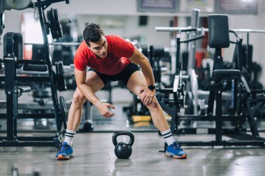 Spor salonunda egzersiz yapan yakışıklı bir genç.