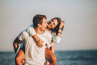 Genç adam sahildeki kız arkadaşına biniyor..