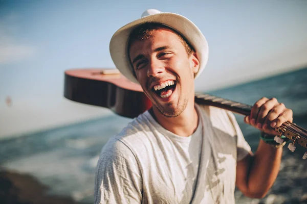 Sonriente Joven Caminando Por Playa Sosteniendo Una Guitarra Sus Manos — Foto de Stock