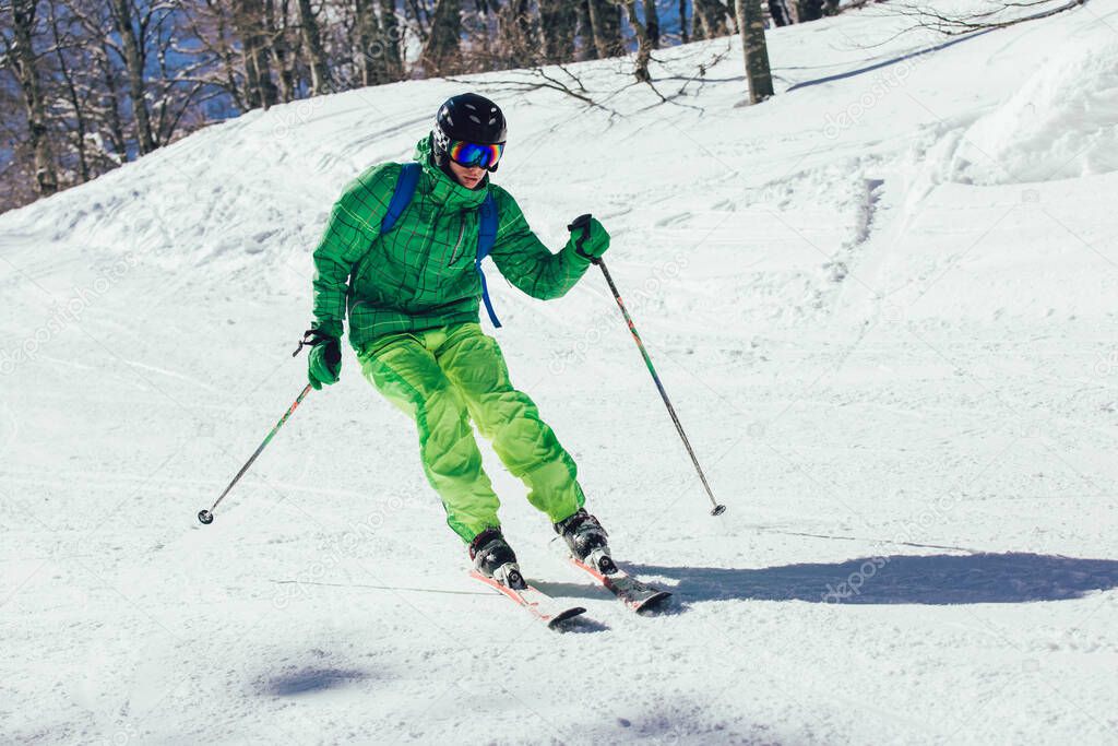 Skier in mountains. Professional skier athlete skiing of ski resort.Winter vacation and sport concept.