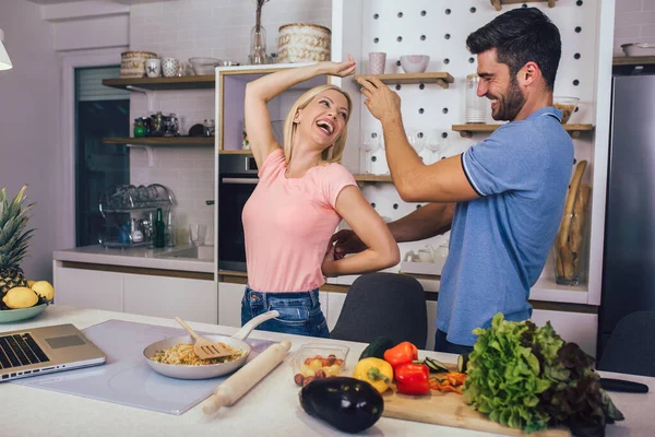 若いカップルは笑顔で家でキッチンで健康食品を調理しながら — ストック写真
