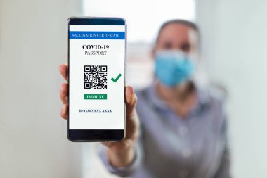 Aşı, hastalık dokunulmazlığı pasaportu, sağlık ve gözetim konseptleri. COVID-19 için geçerli bir dijital aşı sertifikası gösteren akıllı telefon
