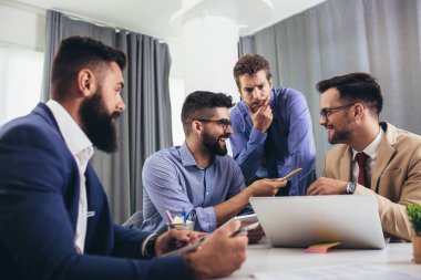 Toplantı odasında iş arkadaşları, birlikte masaya oturmak, fikirleri paylaşmak, proje stratejisini tartışmak..