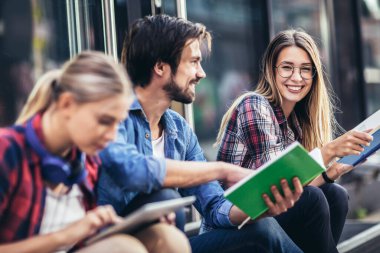 Eğitim, kampüs, arkadaşlık ve insan konsepti. Bir grup mutlu öğrenci dışarıda.