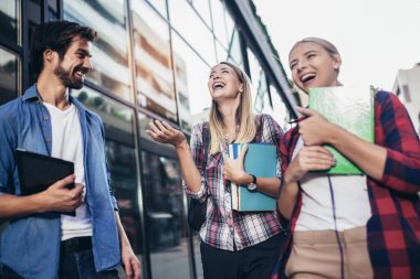 Eğitim, kampüs, arkadaşlık ve insan konsepti. Bir grup mutlu öğrenci dışarıda.