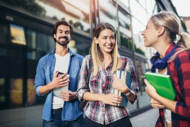 Eğitim, kampüs, arkadaşlık ve insan konsepti. Bir grup mutlu öğrenci dışarıda.