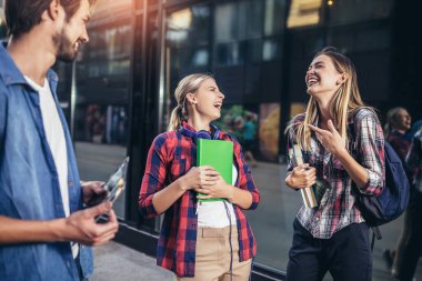 Eğitim, kampüs, arkadaşlık ve insan konsepti. Bir grup mutlu öğrenci dışarıda.