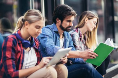 Eğitim, kampüs, arkadaşlık ve insan konsepti. Bir grup mutlu öğrenci dışarıda.