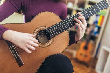 Evde gitarla yeni bir ses çalışması yapan bir kız, kapat..