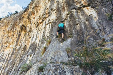 Tırmanışçı kaya duvarına tırmanıyor. Tırmanış takımları. Tırmanma ekipmanı.