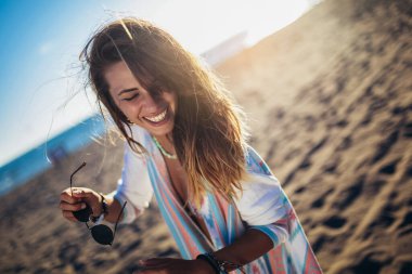 Arka planda arkadaşları olan mutlu genç bir kadın. Bir grup arkadaş plaj tatilinde eğleniyor..