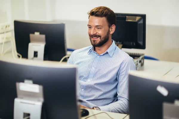 Man working on computer in computer lab.