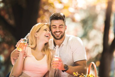 Mutlu romantik çift parkta piknik yapıyor. 