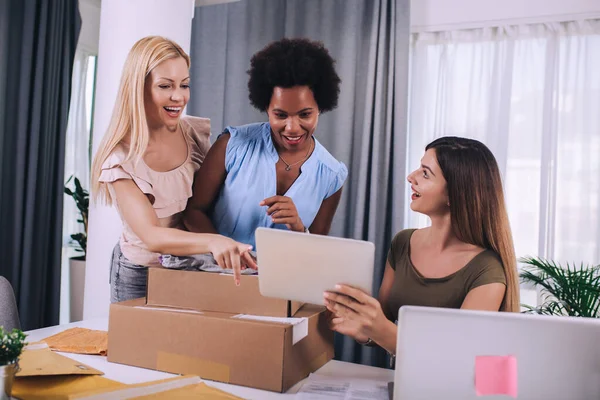 Three young women helped sell their products online and happily prepared to deliver their products. Selling products online or doing freelance work at home concept.