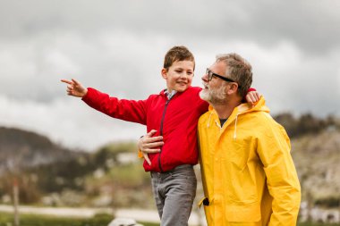 Baba ve oğul yağmurlu bir günde kırsalda