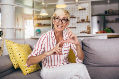 Evde işaret diliyle konuşan yaşlı bir kadın..