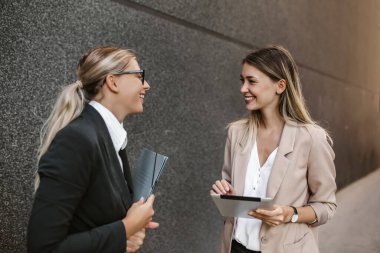 Beyaz kadın asistan iş kadınıyla konuşuyor ve iş hakkında konuşuyor..