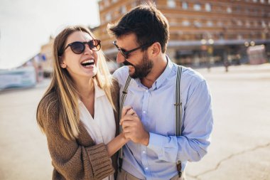 Birbirine aşık çiftler romantik bir yolculukta sokakta kucaklaşıyorlar.