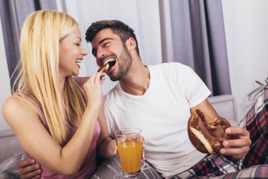 Romantik mutlu çift yatakta kahvaltı yapıyor.