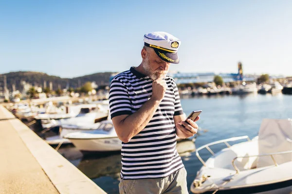 Érett Férfi Áll Tenger Mellett Tengerész Ingben Kalapban Okos Telefonnal — Stock Fotó