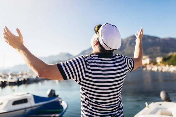 水夫のシャツと帽子を身に着けて海の近くに立つ熟女 — ストック写真