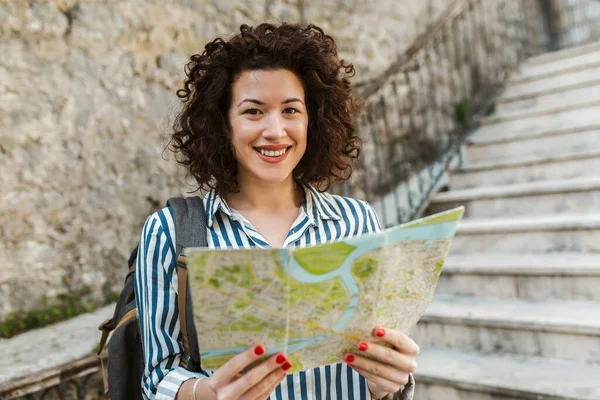 利用地图在欧洲古城街道上行走的女游客 — 图库照片