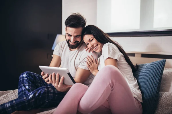 Young Couple Using Tablet Hotel Room While Lying Bed — Stock Photo, Image