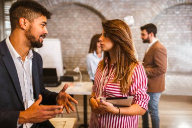 Modern ofiste yeni bir proje üzerinde çalışan iki tasarımcı.