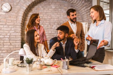 İş projesi ekibi laptopla toplantı odasında birlikte çalışıyor..