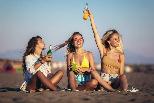 Ευτυχισμένες Νεαρές Γυναίκες Που Κάθονται Στην Παραλία Πίνουν Μπύρα Και — Φωτογραφία Αρχείου