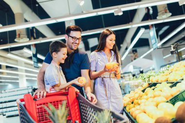 Marketten veya süpermarketten meyve alan mutlu bir aile - alışveriş, yemek, satış, tüketim