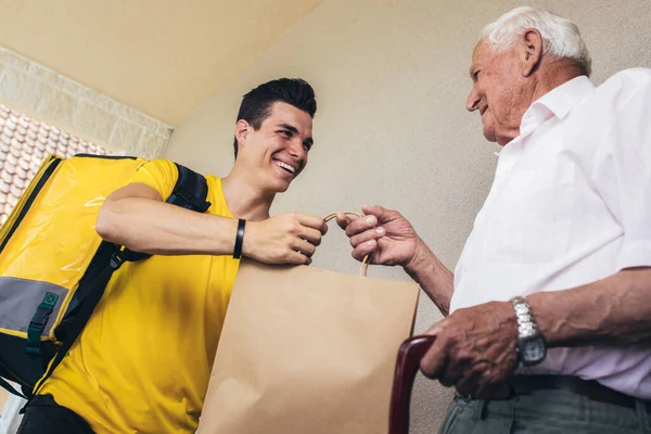 Молодой Волонтер Доставляет Покупки Старшему Мужчине Пожертвование — стоковое фото