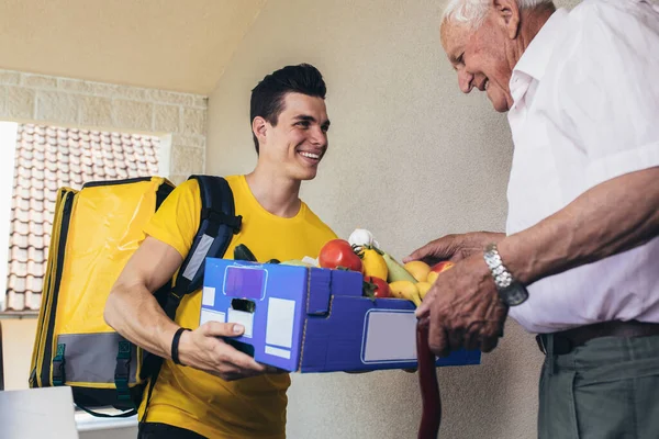 Joven Voluntario Entregando Compras Hombre Mayor Donación —  Fotos de Stock